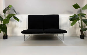 Gebrauchtes schwarzes Brühl Roro Designer Stoff Sofa vor einer Wand, stilvoll und modern eingerichtet.