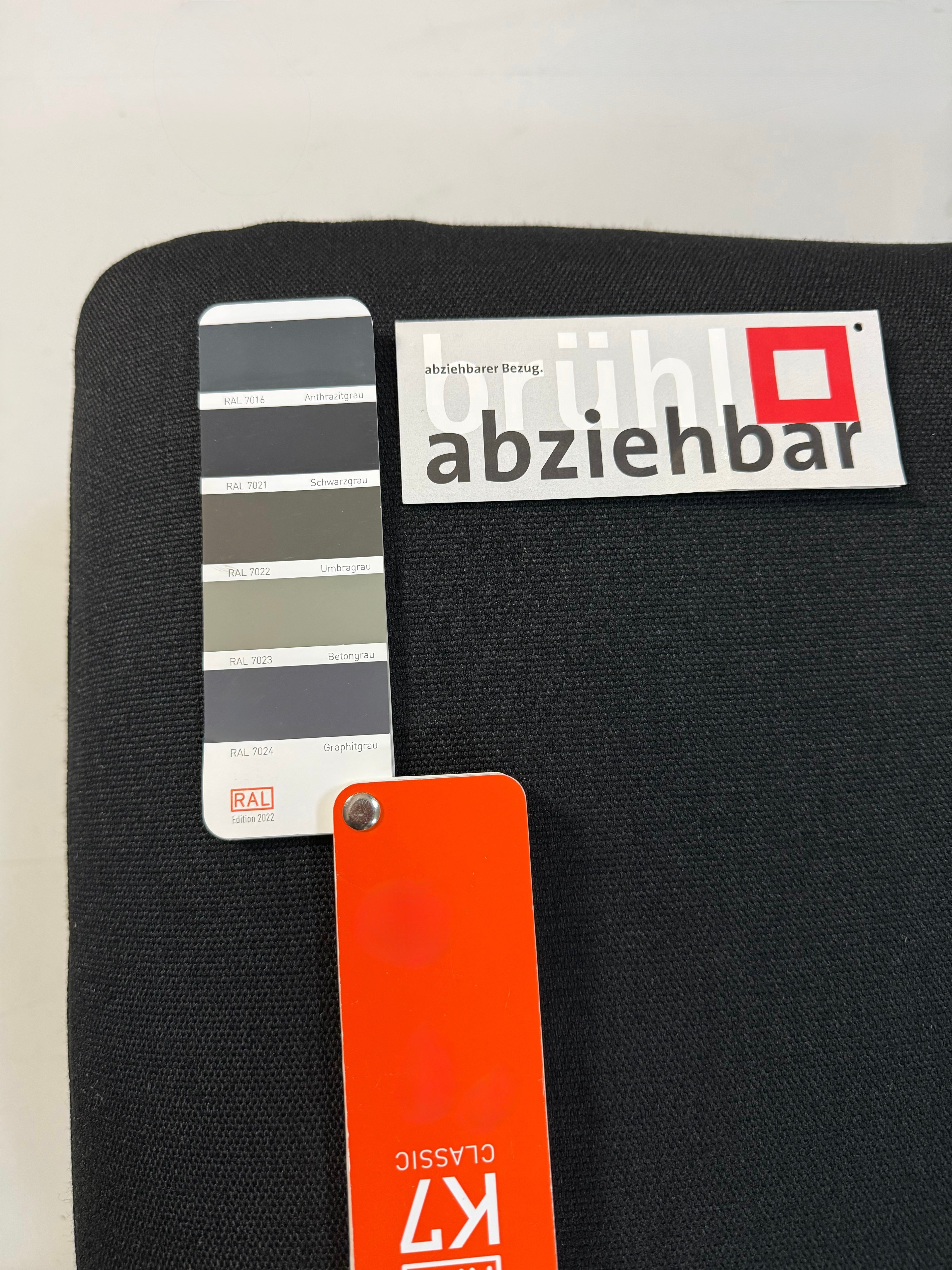 Gebrauchtes schwarzes Brühl Roro Designer Stoff Sofa vor einer Wand, stilvoll und modern eingerichtet.