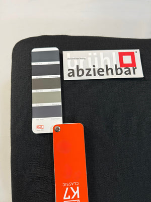 Gebrauchtes schwarzes Brühl Roro Designer Stoff Sofa vor einer Wand, stilvoll und modern eingerichtet.