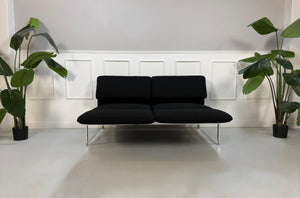 Gebrauchtes schwarzes Brühl Roro Designer Stoff Sofa vor einer Wand, stilvoll und modern eingerichtet.