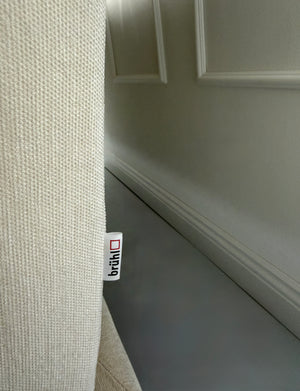 Gebrauchtes beiges Brühl Moule Designer Stoff Sofa vor einer Wand, stilvoll und modern eingerichtet.