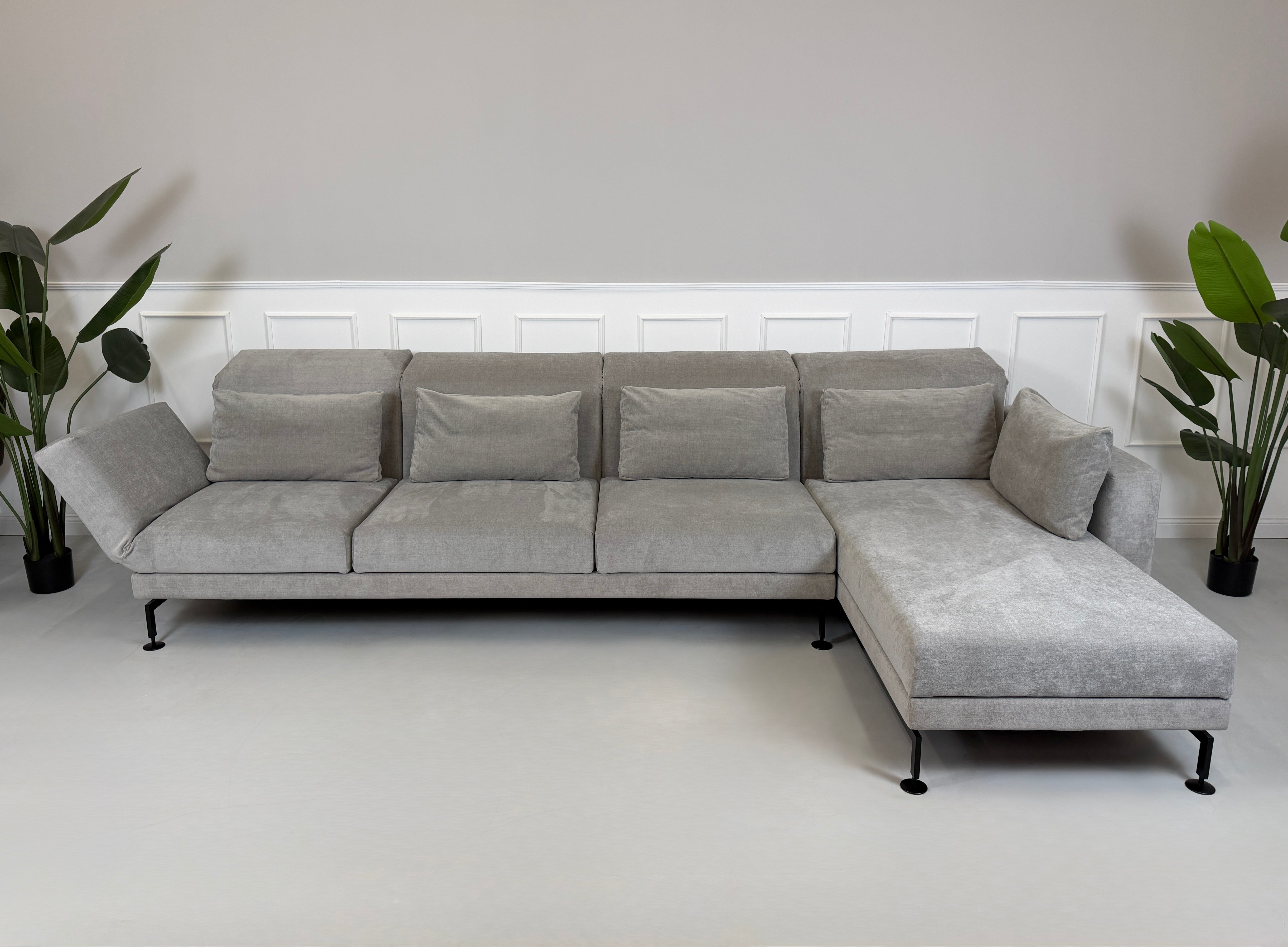 Graues Ausstellungsstück Brühl Moule Designer Stoff Sofa vor einer Wand, stilvoll und modern eingerichtet.