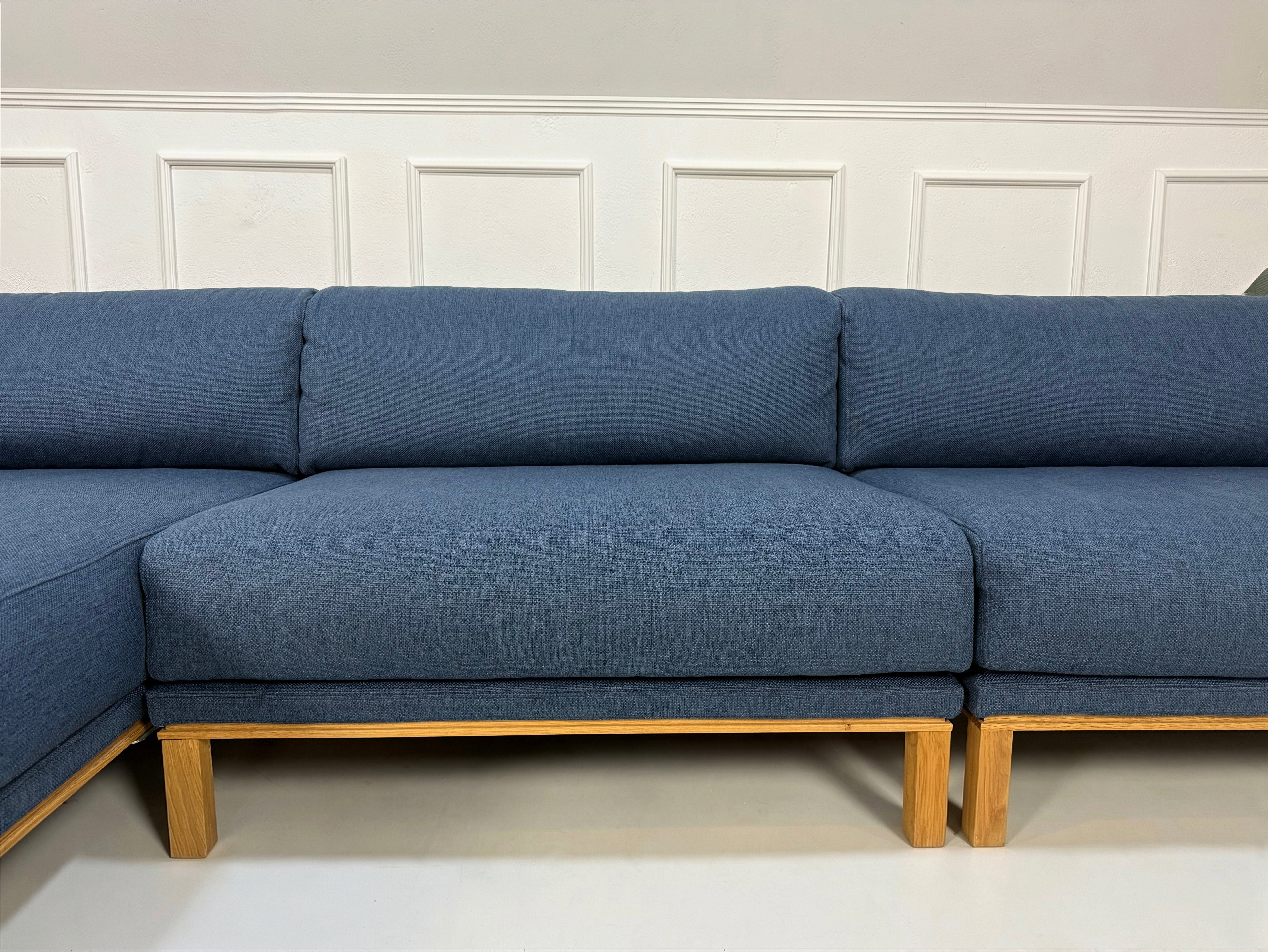 Gebrauchtes blaues Bolia Cosy Designer Stoff Sofa vor einer Wand, stilvoll und modern eingerichtet.