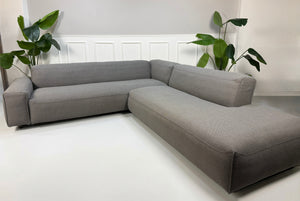 Erneuertes graues Rolf Benz Mio Designer Stoff Sofa vor einer Wand, stilvoll und modern eingerichtet.