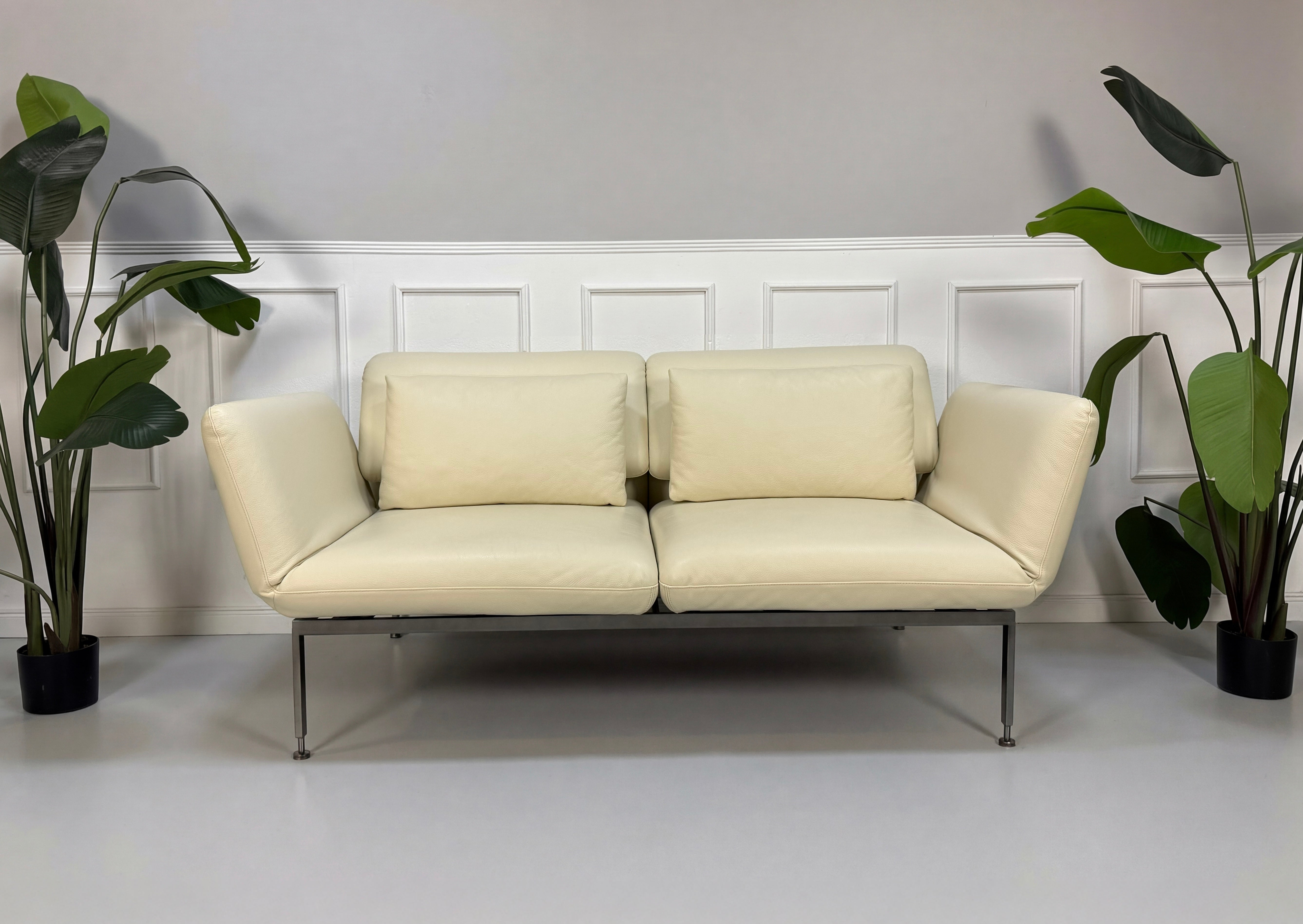 Gebrauchtes beiges Brühl Roro Designer Leder Sofa vor einer Wand, stilvoll und modern eingerichtet.