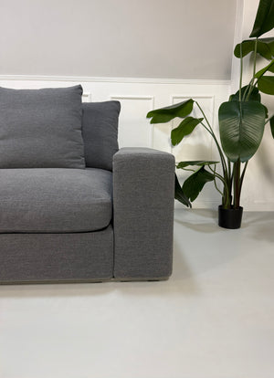 Refurbished graues Flexform Groundpiece Designer Stoff Sofa vor einer Wand, stilvoll und modern eingerichtet.