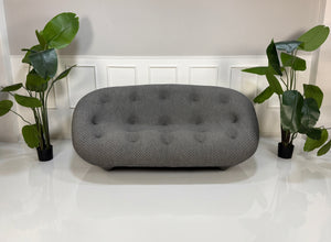 Refurbished graues Ligne Roset Ploum Designer Stoff Sofa vor einer Wand, stilvoll und modern eingerichtet.