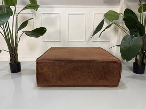Gebrauchtes braunes COR Trio Designer Stoff Sofa vor einer Wand, stilvoll und modern eingerichtet.