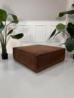 Gebrauchtes braunes COR Trio Designer Stoff Sofa vor einer Wand, stilvoll und modern eingerichtet.