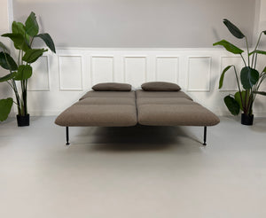 Ausstellungsstück Brühl Roro in braun Designer Stoff Sofa vor einer Wand, stilvoll und modern eingerichtet.