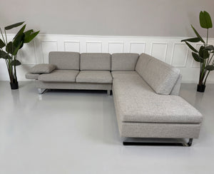 Gebrauchtes graues Brühl Alba Designer Stoff Sofa vor einer Wand, stilvoll und modern eingerichtet