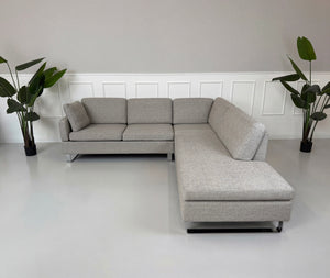 Gebrauchtes graues Brühl Alba Designer Stoff Sofa vor einer Wand, stilvoll und modern eingerichtet