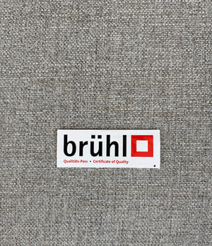 Gebrauchtes graues Brühl Alba Designer Stoff Sofa vor einer Wand, stilvoll und modern eingerichtet