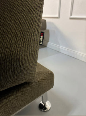 Gebrauchtes braunes Brühl Moule Designer Stoff Sofa vor einer Wand, stilvoll und modern eingerichtet.