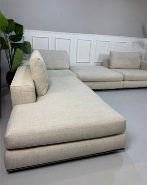 Gebrauchtes beiges Minotti Hamilton Designer Stoff Sofa vor einer Wand, stilvoll und modern eingerichtet