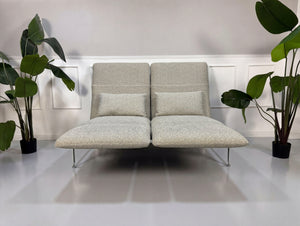 Gebrauchtes graues Brühl Roro Designer Stoff Sofa vor einer Wand, stilvoll und modern eingerichtet.