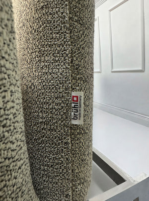 Gebrauchtes graues Brühl Roro Designer Stoff Sofa vor einer Wand, stilvoll und modern eingerichtet.