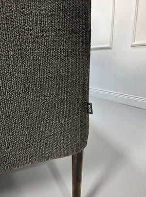 Gebrauchtes graues COR Pilotis Designer Stoff Sofa vor einer Wand, stilvoll und modern eingerichtet.