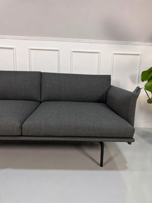 Gebrauchtes graues Muuto Outline Designer Stoff Sofa vor einer Wand, stilvoll und modern eingerichtet.