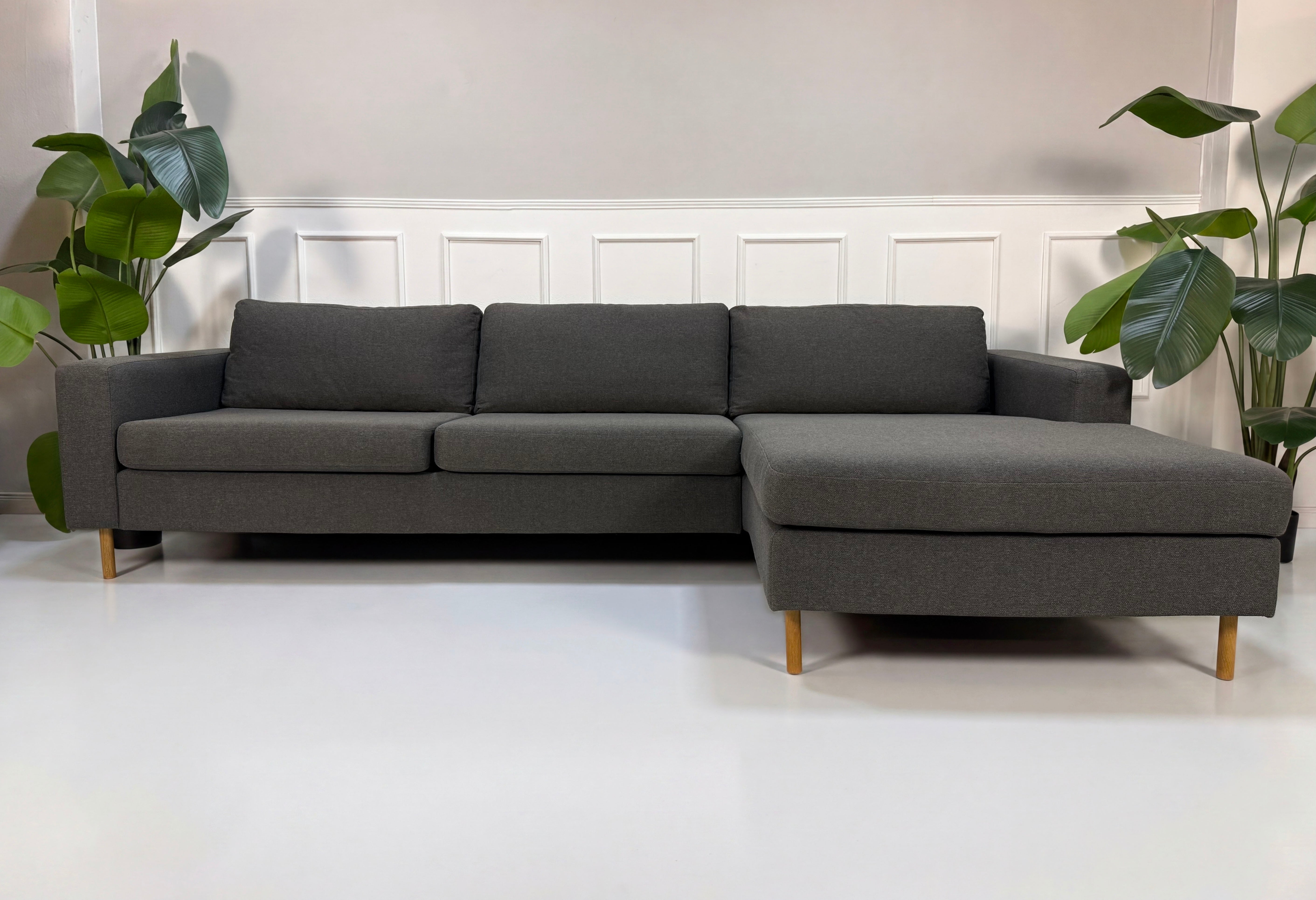 Gebrauchtes graues Bolia Scandinavia Designer Stoff Sofa vor einer Wand, stilvoll und modern eingerichtet.