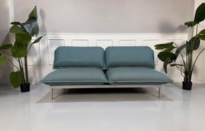 Gebrauchtes blaues Rolf Benz Nova Designer Stoff Sofa vor einer Wand, stilvoll und modern eingerichtet.