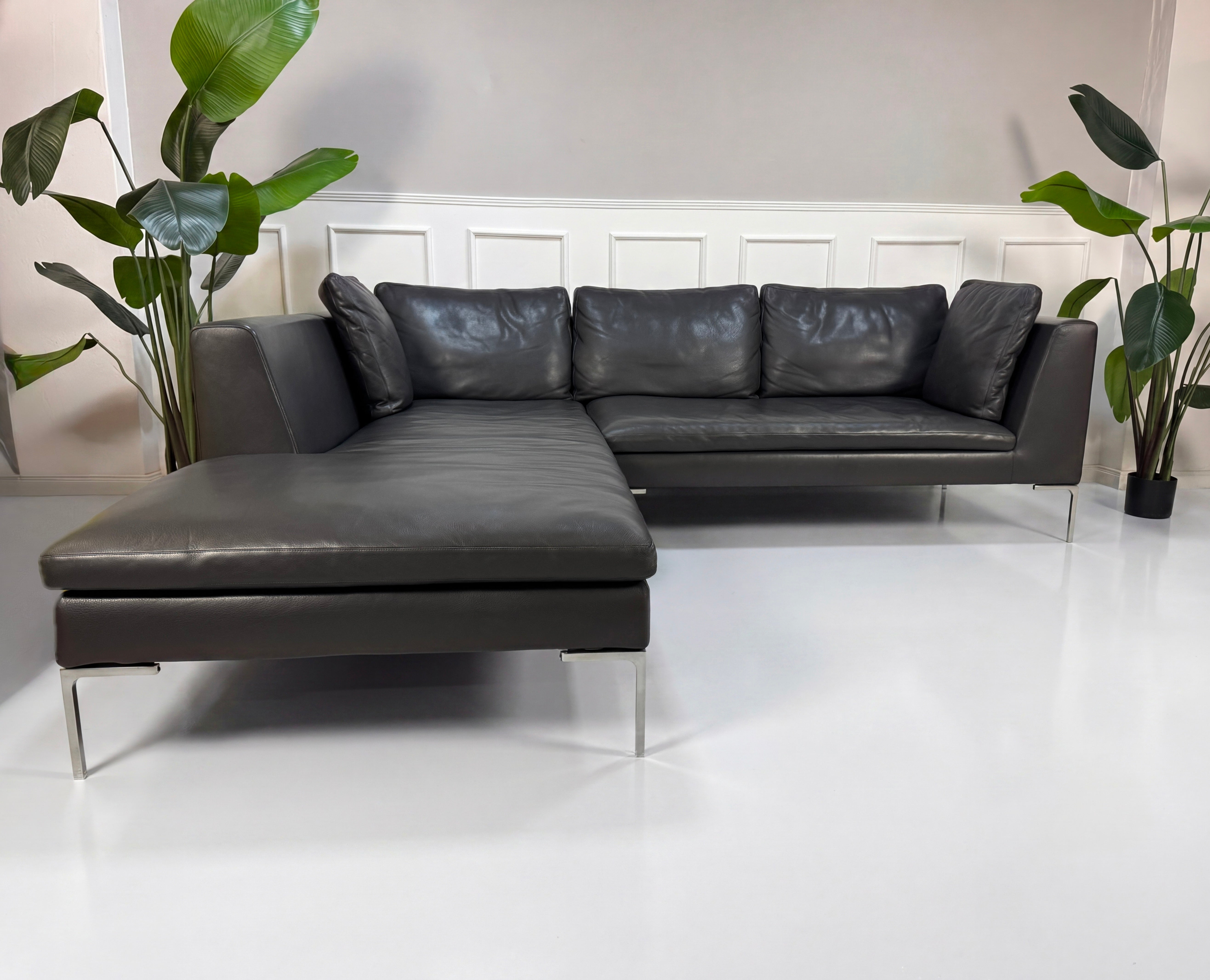 Gebrauchtes graues B&B Italia Charles Designer Leder Sofa vor einer Wand, stilvoll und modern eingerichtet.