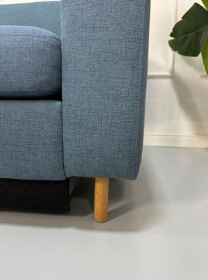 Gebrauchtes blaues Bolia Scandinavia Designer Stoff Sofa vor einer Wand, stilvoll und modern eingerichtet.