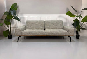 Gebrauchtes graues Koinor Hiero Designer Stoff Sofa vor einer Wand, stilvoll und modern eingerichtet.
