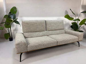 Gebrauchtes graues Koinor Hiero Designer Stoff Sofa vor einer Wand, stilvoll und modern eingerichtet.
