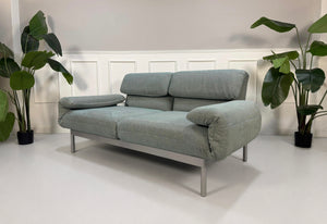 Gebrauchtes graues mint Rolf Benz Plura Designer Stoff Sofa vor einer Wand, stilvoll und modern eingerichtet.