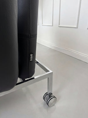 Gebrauchtes schwarzes Brühl Roro Small Designer Leder Sofa vor einer Wand, stilvoll und modern eingerichtet.