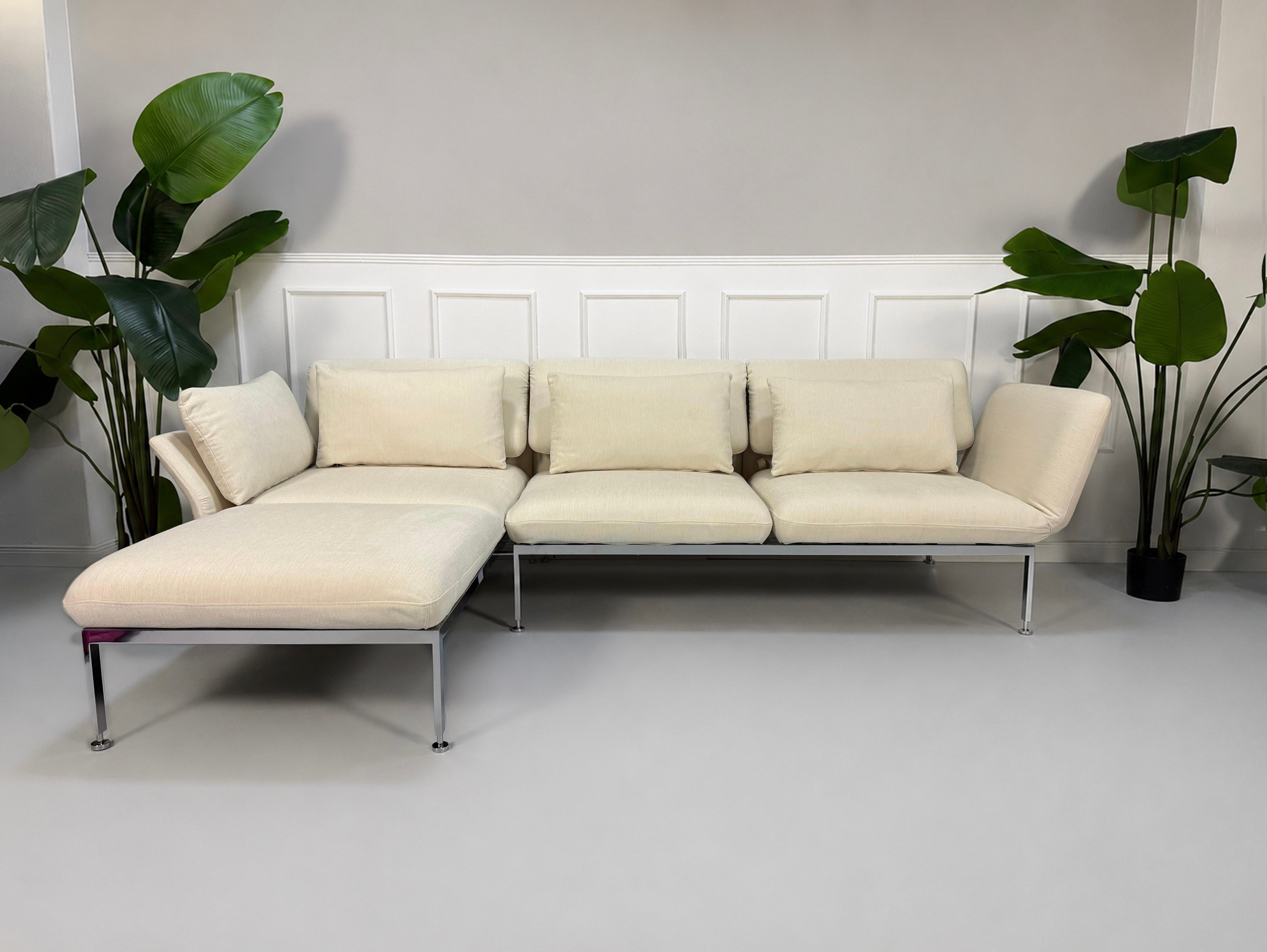 Gebrauchtes beiges Brühl Roro Designer Stoff Ecksofa vor einer Wand, stilvoll und modern eingerichtet.