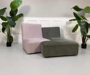 Gebrauchtes grau pinkes Ligne Roset Confluences Designer Stoff Sofa vor einer Wand, stilvoll und modern eingerichtet.
