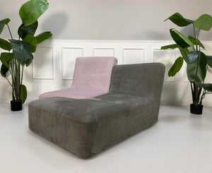 Gebrauchtes grau pinkes Ligne Roset Confluences Designer Stoff Sofa vor einer Wand, stilvoll und modern eingerichtet.