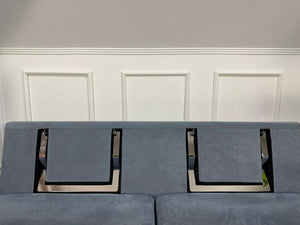 Gebrauchtes blaues Brühl Alba Designer Stoff Sofa vor einer Wand, stilvoll und modern eingerichtet.