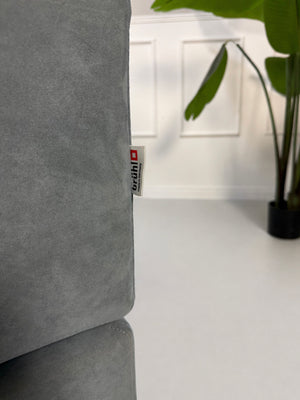 Gebrauchtes blaues Brühl Alba Designer Stoff Sofa vor einer Wand, stilvoll und modern eingerichtet.