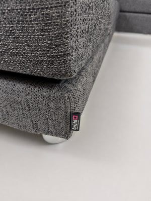 Gebrauchtes graues Brühl Four Two Designer Stoff Sofa vor einer Wand, stilvoll und modern eingerichtet.