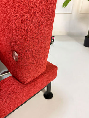 Gebrauchtes rotes Brühl Moule Small Designer Stoff Sofa vor einer Wand, stilvoll und modern eingerichtet.