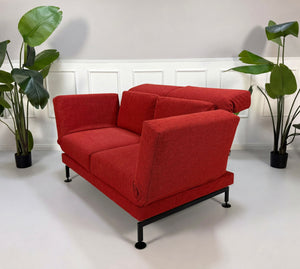 Gebrauchtes rotes Brühl Moule Small Designer Stoff Sofa vor einer Wand, stilvoll und modern eingerichtet.