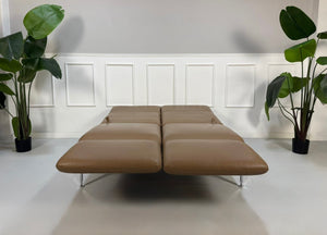 Gebrauchtes braunes Brühl Roro Small Designer Leder Sofa vor einer Wand, stilvoll und modern eingerichtet.