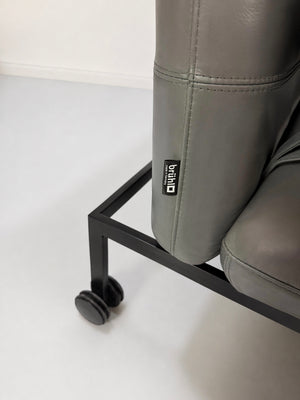 Gebrauchter grauer Brühl Roro Designer Leder Longchair vor einer Wand, stilvoll und modern eingerichtet.