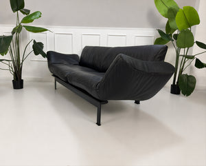 Gebrauchtes schwarzes DeSede Ds 140 Designer Leder Sofa vor einer Wand, stilvoll und modern eingerichtet.