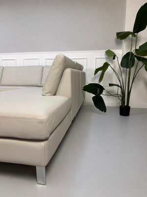 Gebrauchtes graues COR Conseta Designer Leder Sofa vor einer Wand, stilvoll und modern eingerichtet.