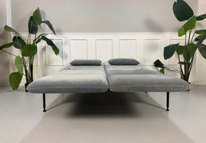 Gebrauchtes graues Brühl Roro Designer Stoff Sofa vor einer Wand, stilvoll und modern eingerichtet.