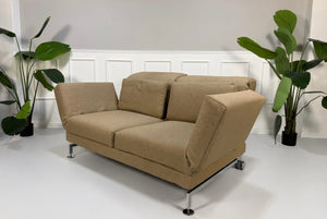 Gebrauchtes beiges Brühl Moule Designer Stoff Sofa vor einer Wand, stilvoll und modern eingerichtet.
