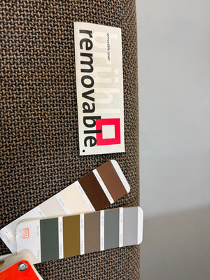 Gebrauchtes braunes Brühl Roro Designer Stoff Ecksofa vor einer Wand, stilvoll und modern eingerichtet.