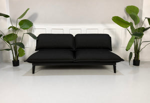 Gebrauchtes schwarzes Rolf Benz Nova Designer Stoff Sofa vor einer Wand, stilvoll und modern eingerichtet.