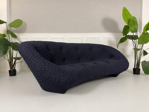 Gebrauchtes blaues Ligne Roset Ploum Designer Stoff Sofa vor einer Wand, stilvoll und modern eingerichtet.