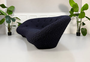 Gebrauchtes blaues Ligne Roset Ploum Designer Stoff Sofa vor einer Wand, stilvoll und modern eingerichtet.