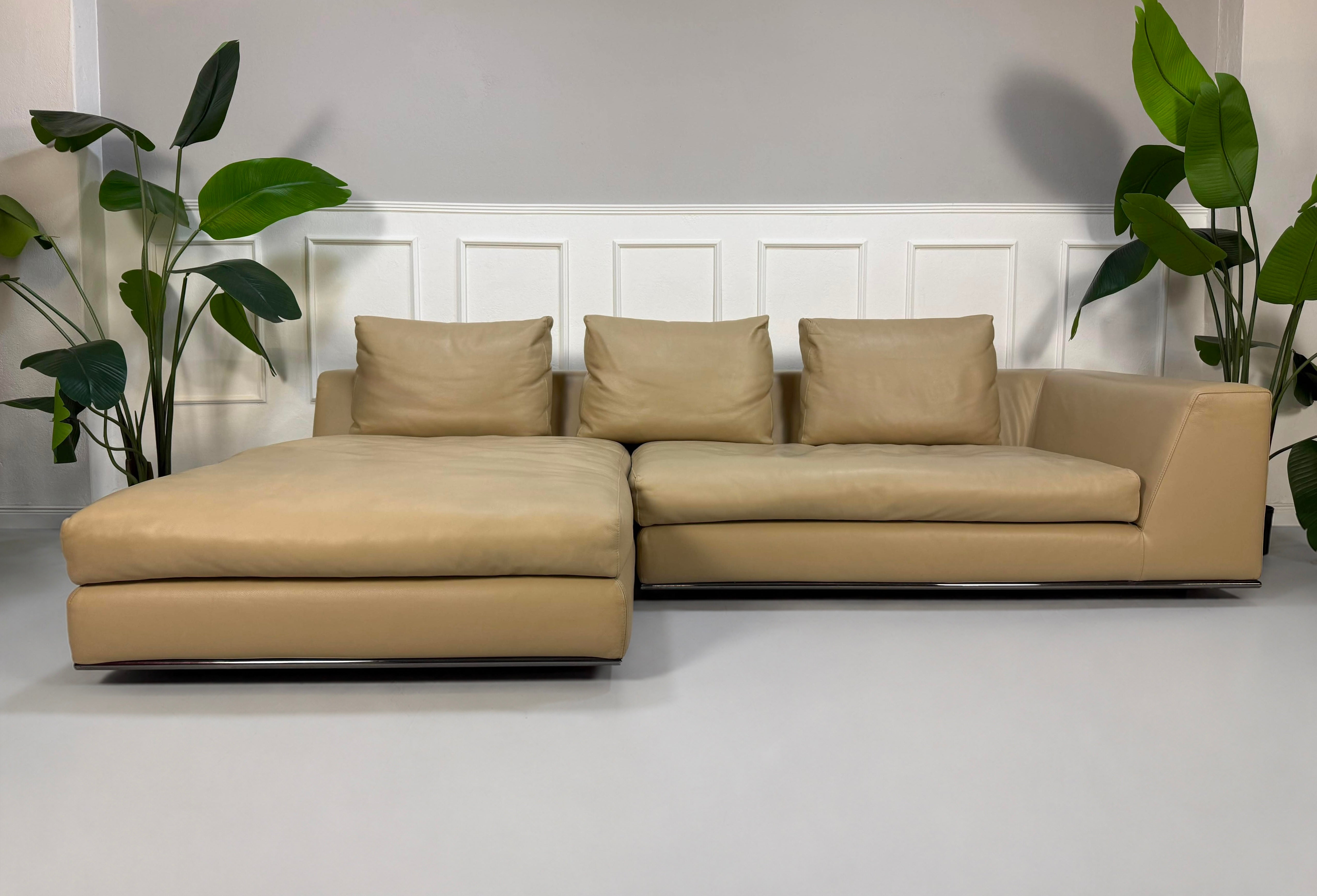 Gebrauchtes beiges Minotti Hamilton Designer Leder Sofa vor einer Wand, stilvoll und modern eingerichtet.